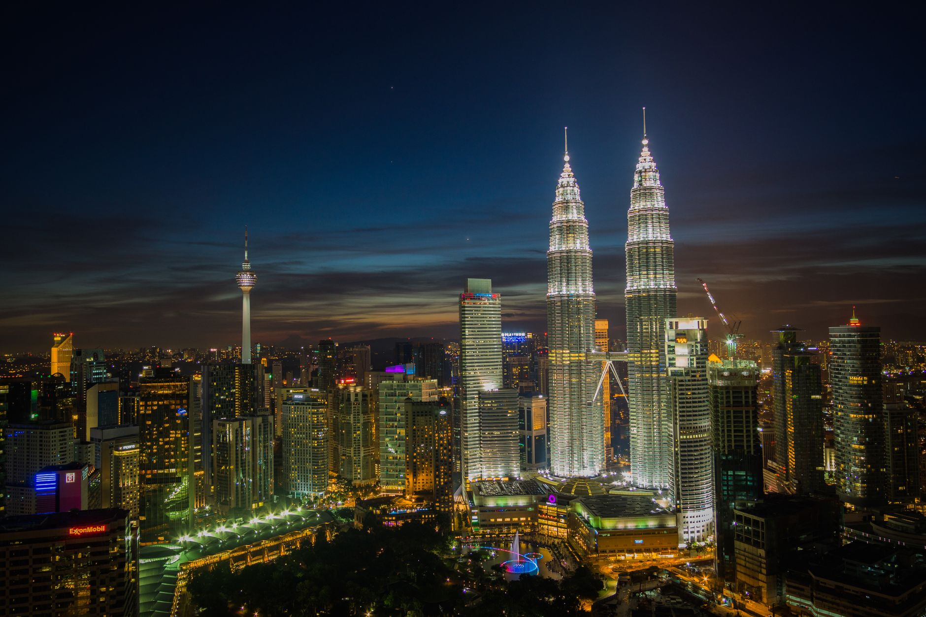 Dazzling night skyline of Kuala Lumpur with iconic Petronas Towers illuminated.