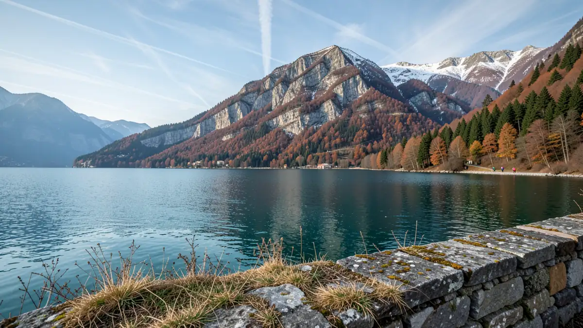 Blick über den Gardasee von Riva del Garda auf die umliegenden Berge im Herbstlicht