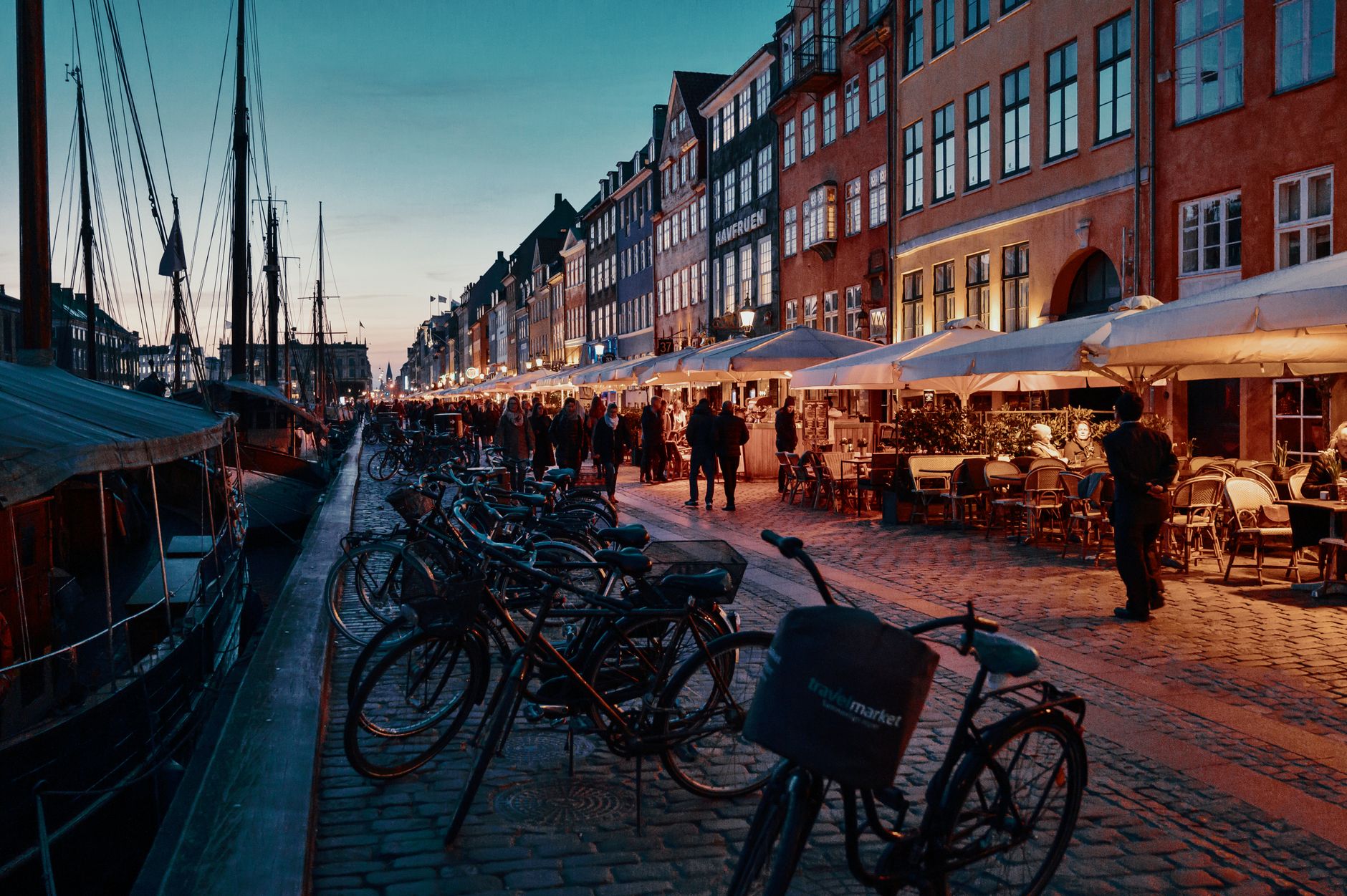 Charming evening scene with bicycles and people in Nyhavn, Copenhagen, Denmark.