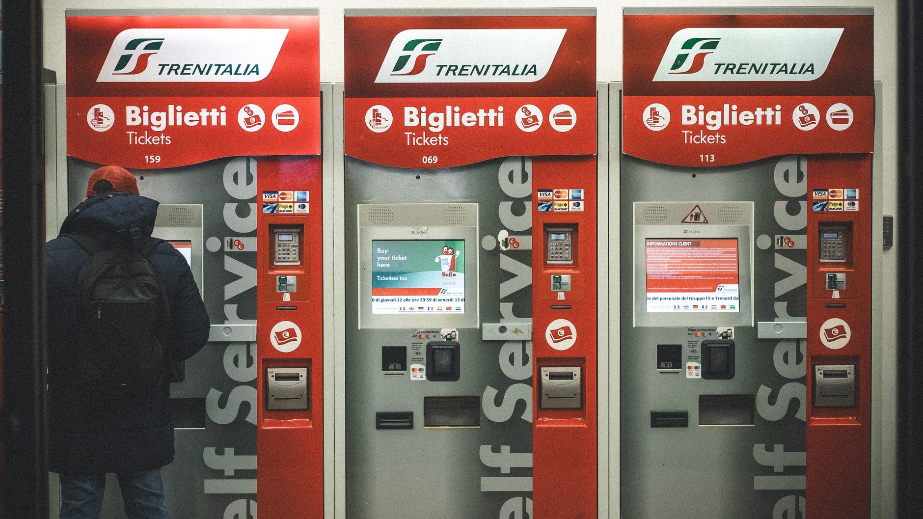 A traveler uses Trenitalia ticket machines at a station in Florence, Italy.
