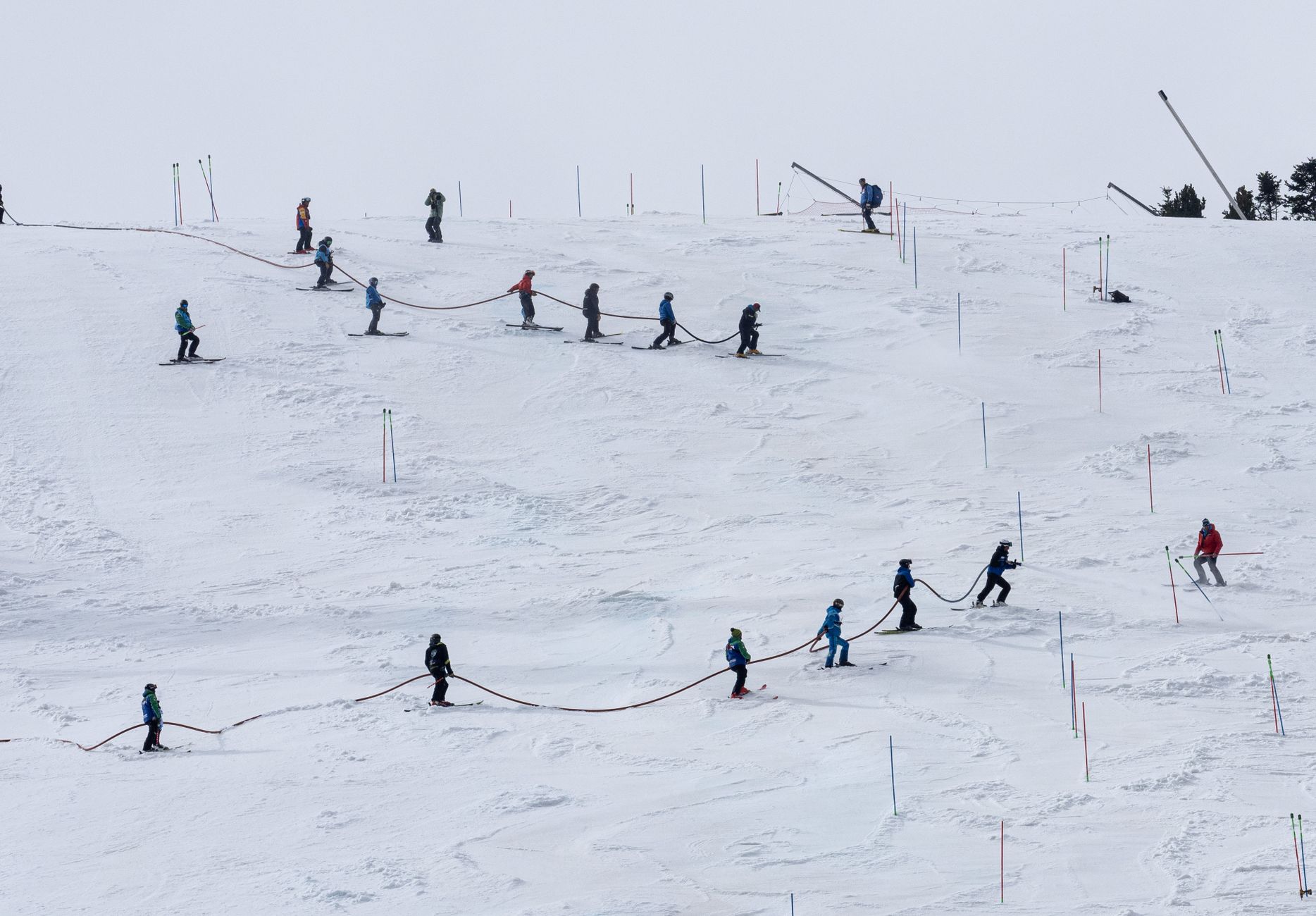 Group of skiers ascending snowy slopes in Andorra during winter training session.