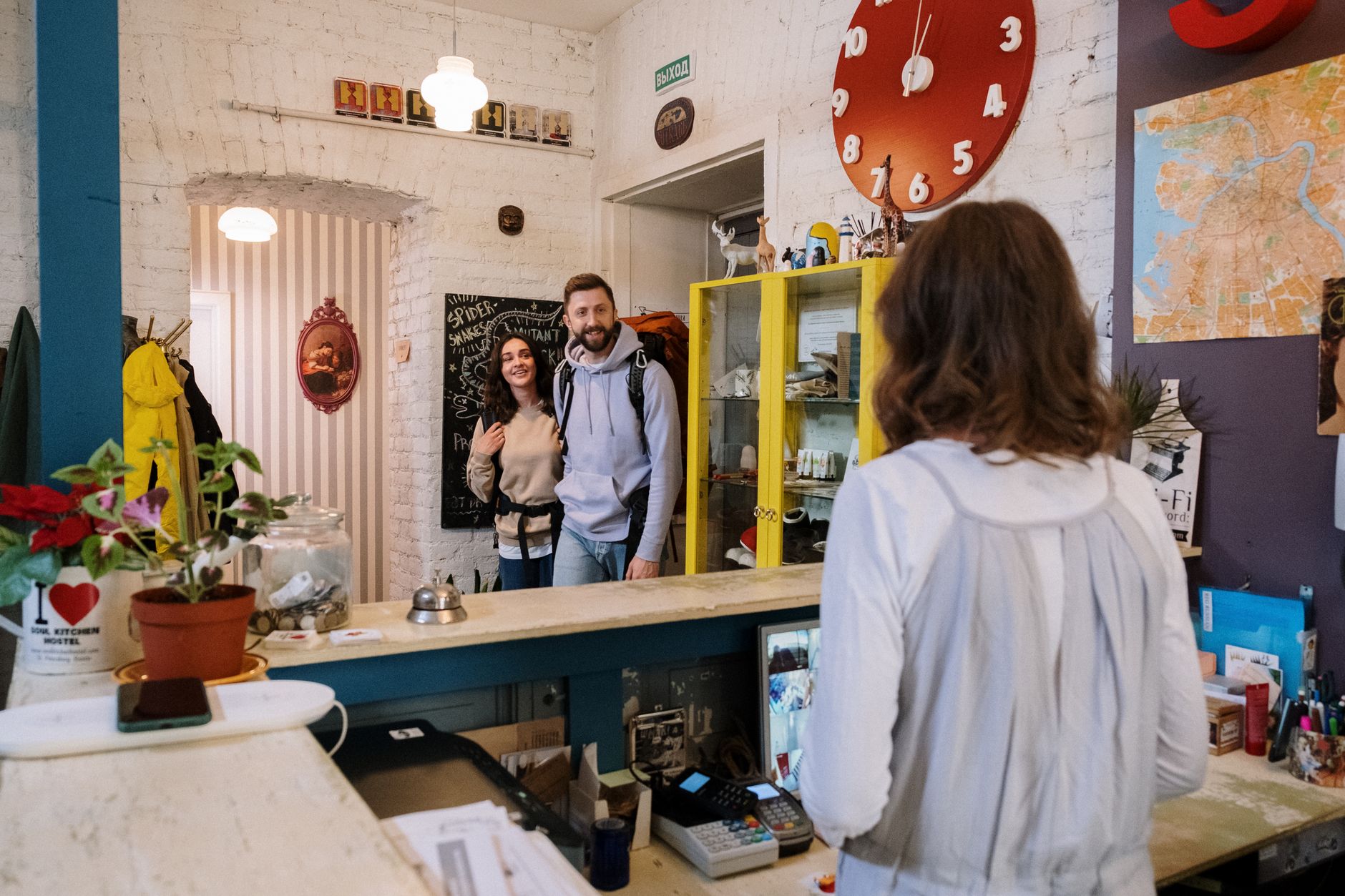 Friendly hostel reception area with travelers checking in, providing a warm and welcoming atmosphere