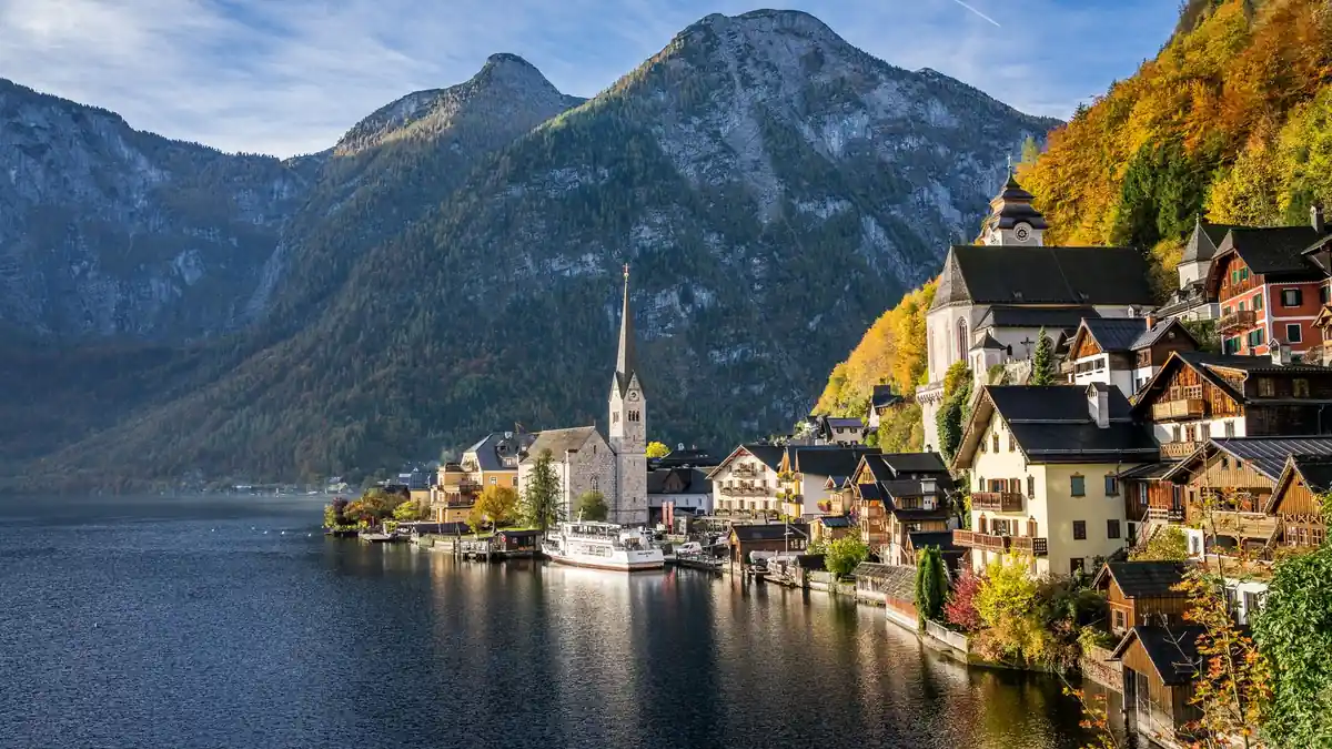 Blick über den Hallstätter See auf die Pfarrkirche und die Häuser am Hang, früher Morgen